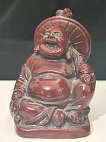 Front view of burgundy resin Laughing Buddha showing face, belly and overall finish