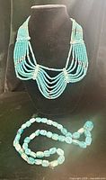 Multi-strand collar displayed on bust with long scarab strand laid in front