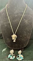 Necklace on stand with earrings below showing full set
