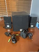 Front view of subwoofer, two satellites, power adapter and audio cables