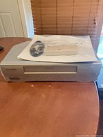 Front and top view of Emerson EWW404 VCR with accessories bagged on top
