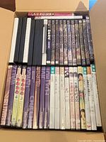 Open box showing two rows of Japanese DVDs in cases