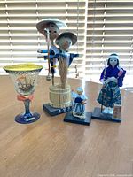 Group shot of three dolls and goblet
