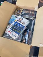 Open carton showing mixed DVDs and Blu-ray discs in cases and sleeves