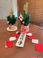Both Kadomatsu decorations with flag and calligraphy strip displayed on tabletop