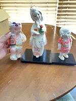 All three Japanese porcelain figurines with two display bases