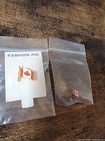 Both Canadian flag lapel pins in separate zip bags