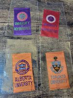 All four university tobacco silks displayed inside protective sleeves