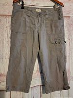 Front view of gray cargo capri pants hanging