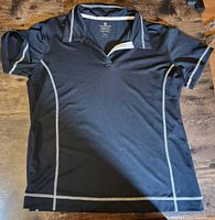 Full view of black athletic shirt laid flat