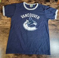 Front view of navy T-shirt with Canucks logo