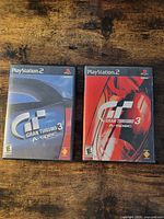 Front view of both PS2 Gran Turismo 3 A-Spec cases, blue and red cover variants