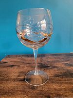 Front view of balloon wine glass showing gold and black swirl design and overall condition