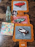 All items grouped: Coca-Cola bottle, Grand Prix game, three Perfect Circle signs, Coca-Cola card