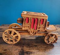 Full side view of wooden stagecoach showing overall design and wheels