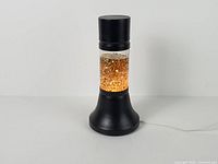 Full view of gold glitter motion lamp illuminated