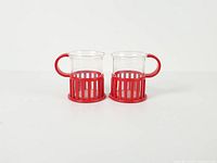Front view of both glass cups within red plastic holders