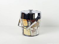 Full view of chrome ice bucket with label collage and handle