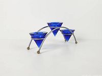Three-arm brushed metal candelabra with cobalt blue glass cones angled view