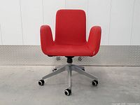 Front view of red IKEA Patrik office chair showing upholstery, arms, and base