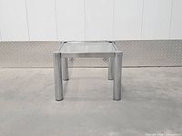 Full view of square chrome and glass side table