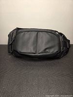 Front view of black nylon sling bag