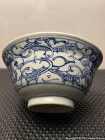 Side view of porcelain tea bowl showing blue floral decoration