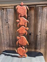 Full view of teak wall decor with five turtles