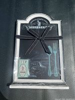 Front view of packaged chalkboard showing frame, ribbon, chalk pack