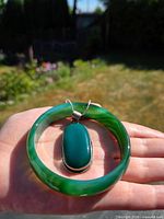 Pendant and bangle in hand showing size, color, stone translucency