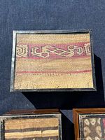Top view of largest box showing beige textile with red geometric border and silver frame