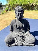 Front angled view of seated Buddha statue on table