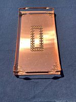 Top view of copper tray showing etched pattern and handles