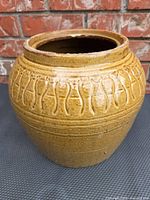 Front view of glazed stoneware jar showing decorative band and mouth