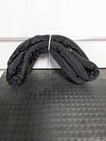 Folded black synthetic winch rope displayed on mat
