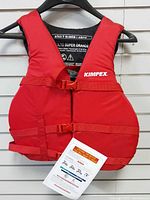 Front of red Kimpex life jacket showing straps, buckles and hang tag