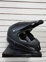Left side profile of matte black Z1R helmet with peak visor and interior padding visible