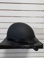 Left side view of matte black open-face helmet on display base