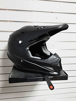 Left side view of matte black Z1R Rise helmet on display shelf
