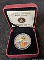 Coin in capsule inside presentation case showing Evening Grosbeak design