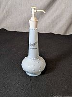 Full view of blue hobnail glass Jergens lotion dispenser with pump