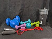 Group shot of all dumbbells, jump rope and Nike bottle