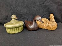 Front view of all three duck items: two wooden figurines and green ceramic lidded trinket box