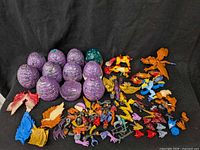 Group of ten purple eggs, one green egg, loose creature parts spread out