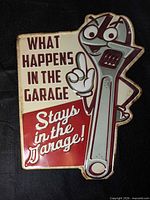 Front of embossed tin sign with text and cartoon wrench