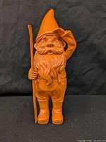 Front view of orange resin garden gnome statue
