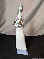 Front view of porcelain figurine woman with dog
