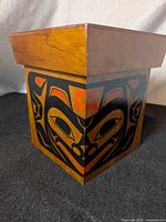 Three-quarter view of wood box showing formline design and lid