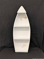 Front view of boat-shaped wall shelf showing white interior and stains