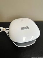 Top view showing Comfier logo, three control buttons and charging cord